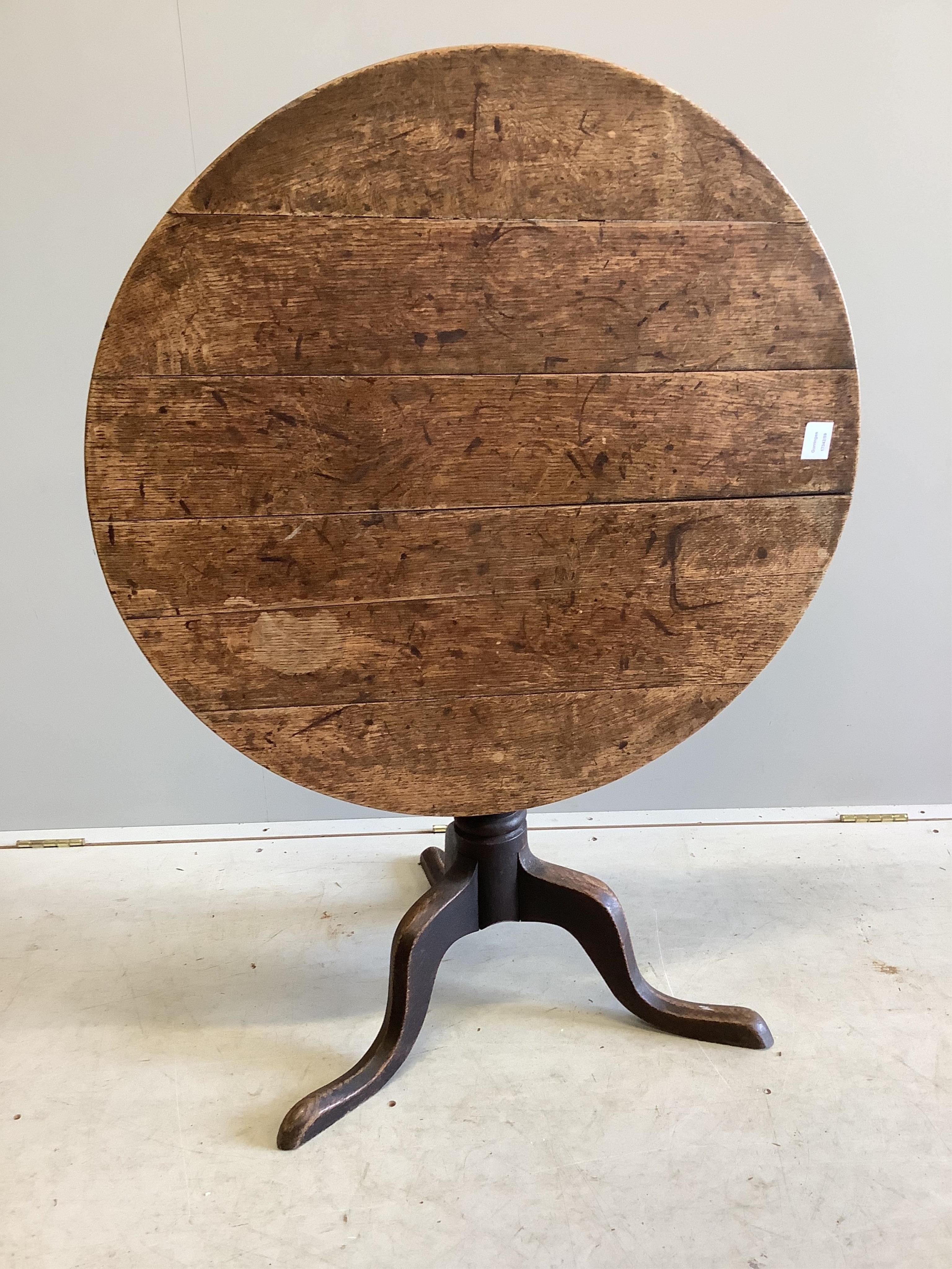 A George III circular oak tilt top tripod table, diameter 82cm, height 70cm. Condition - fair